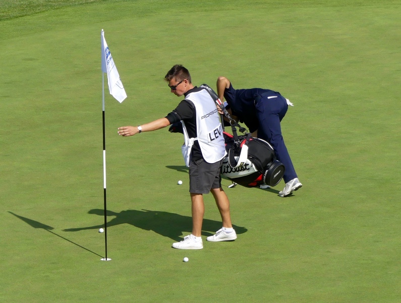 Alexander Levy mit Caddie verdeutlicht neue Golfregeln zum Ballbwegen auf dem Grün